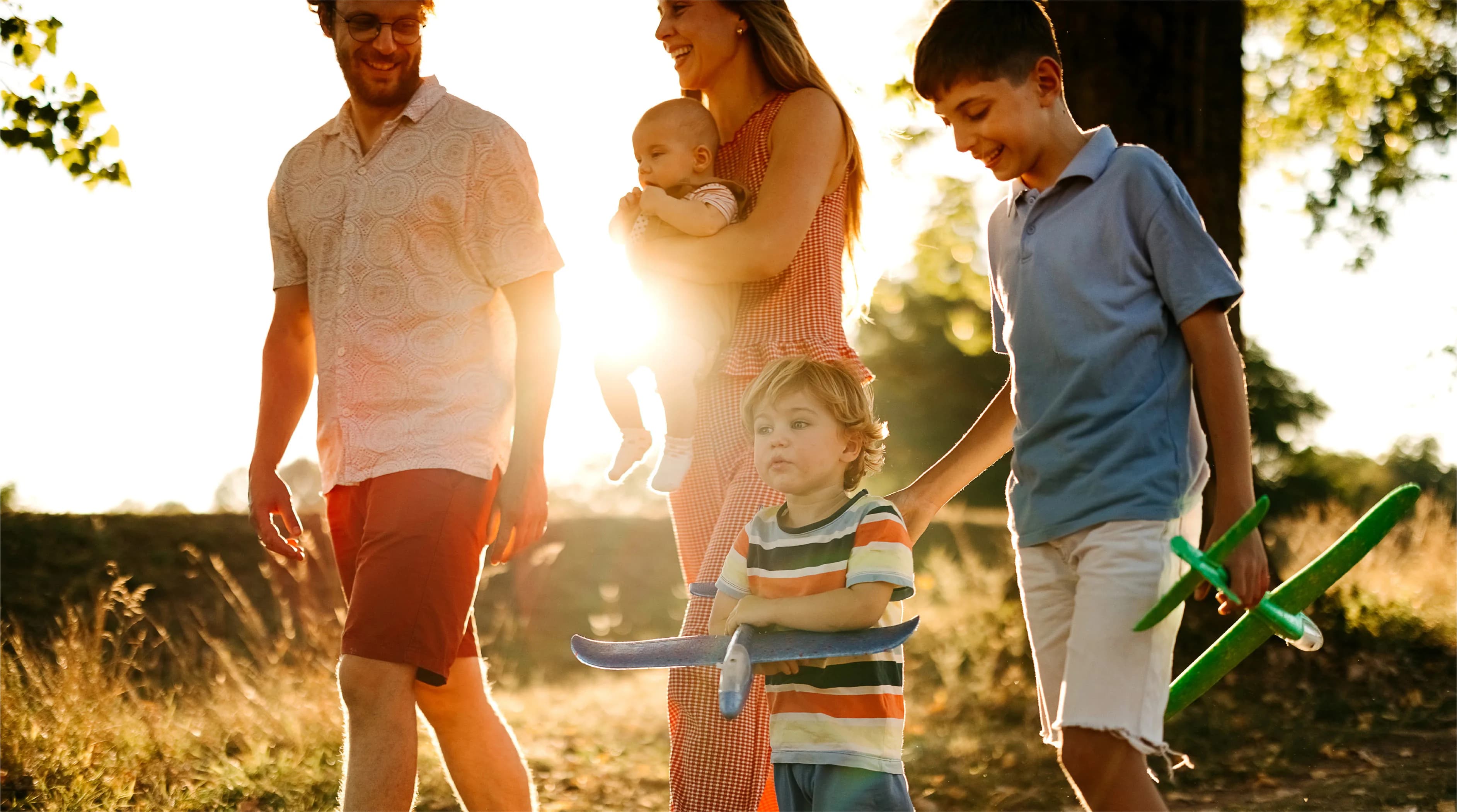 Lifestyle photograph labelled Caledon Station in the Bolton Place marketing set — a family walking outdoors near Bolton, Caledon. Not a rendering of the community.
